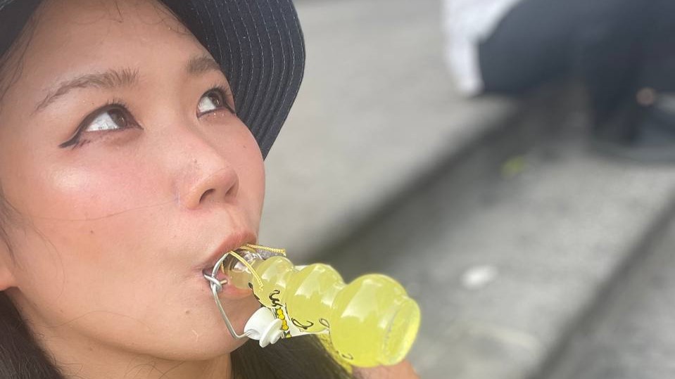 Hazu in the Amalfi Coast posing with a limoncello bottle in her mouth while looking at the sky.