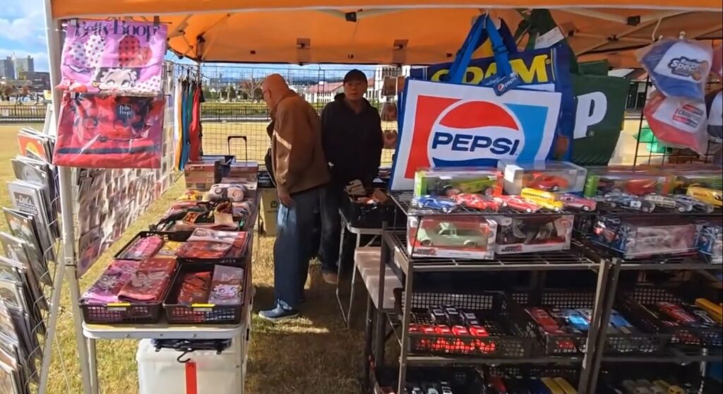 A pop up shop after the car exhibit showing mini cars and brand bags.