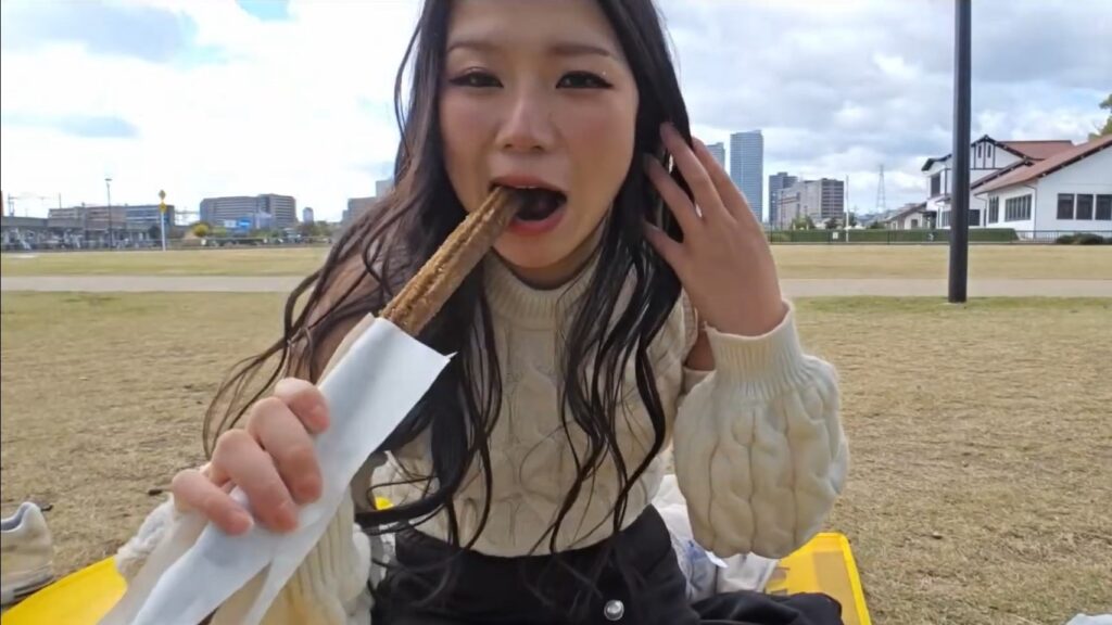 Hazu eating her churro while sitting on her mario picnic mat.