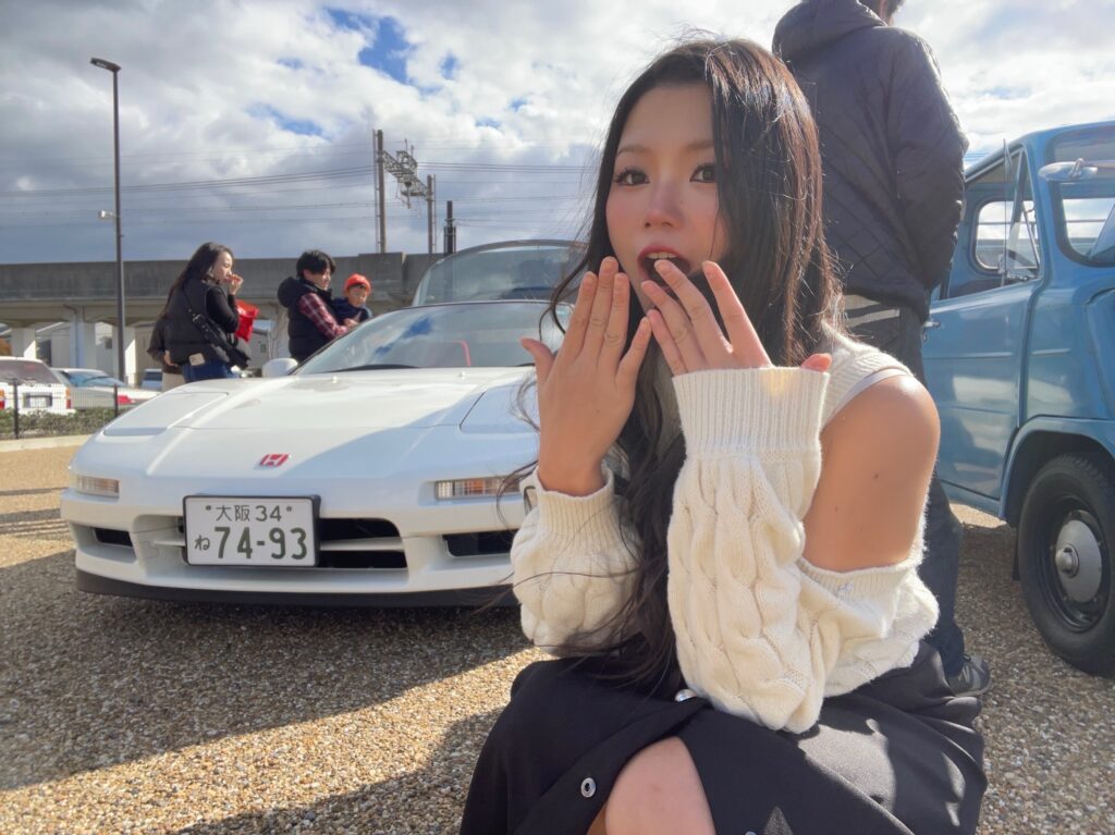 Hazu posing in front of the Honda NSX she voted for.