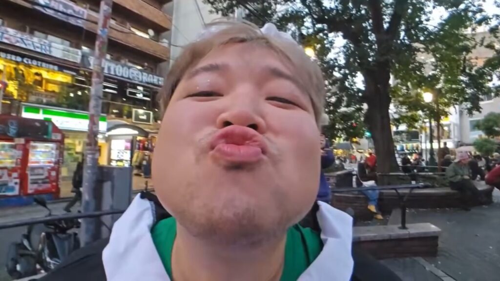 Hyubsama in full makeup and a maid outfit making kissy faces at the camera.