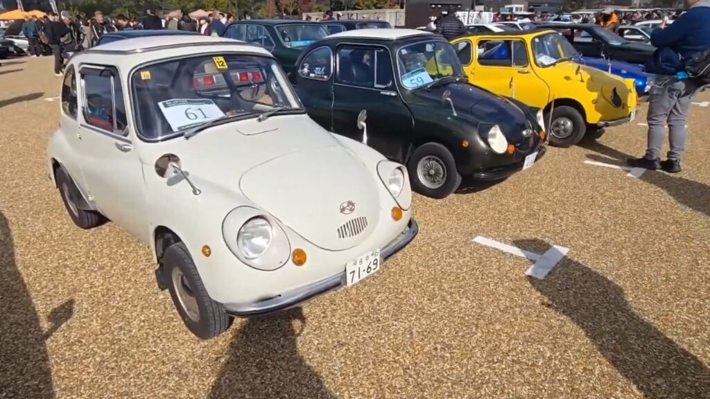 Identification number papers on 3 Subaru 360 cars in a row.