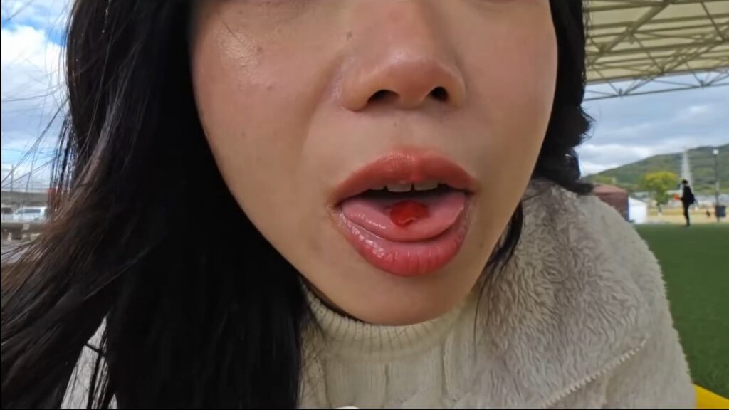 Hazu showing a piece of strawberry on her tongue to show how much strawberry was in the Frappuccino.